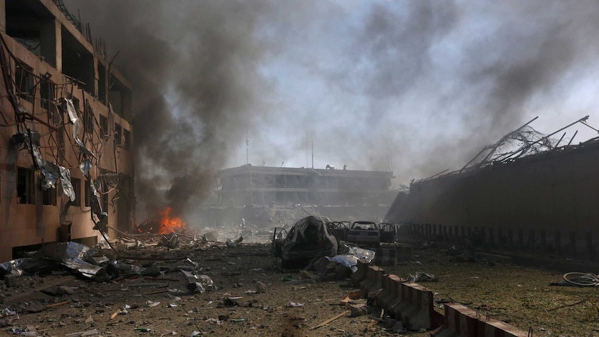 The aftermath of the blast shows a completely destroyed Kabul street with fires and blown out windows in buildings.