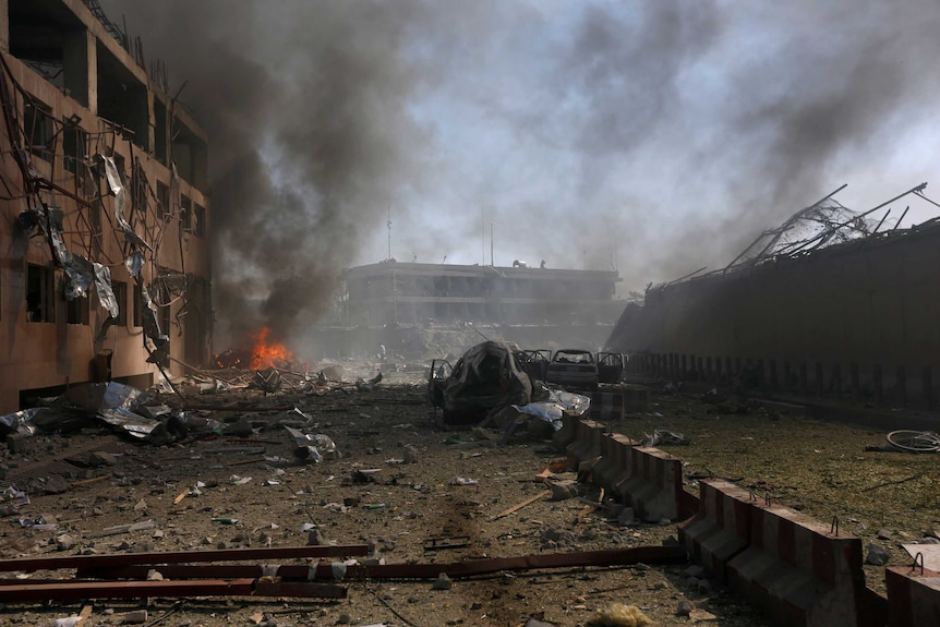 The aftermath of the blast shows a completely destroyed Kabul street with fires and blown out windows in buildings.