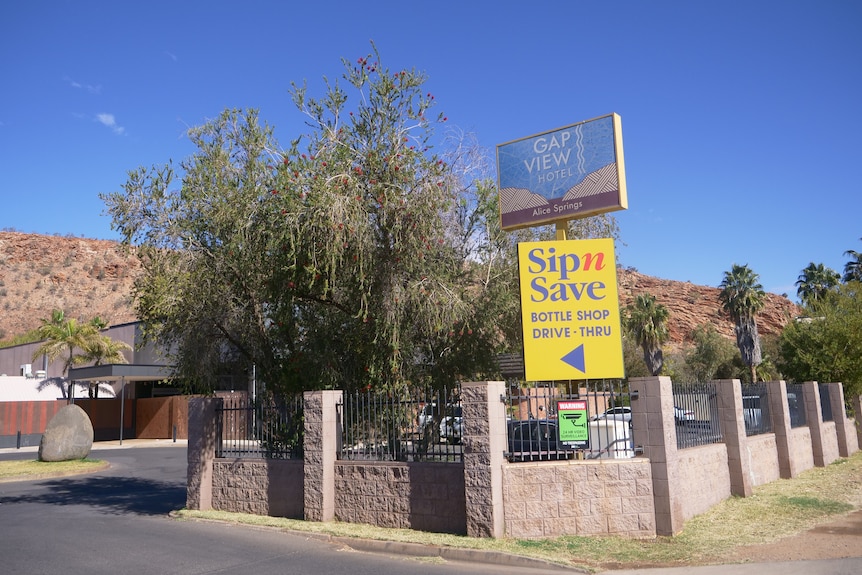 The exterior photo of the Gap View Hotel with a 'warning' sign out the front.