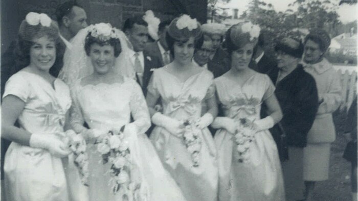 A 1950s bride with three bridesmaids in below the knee dresses.