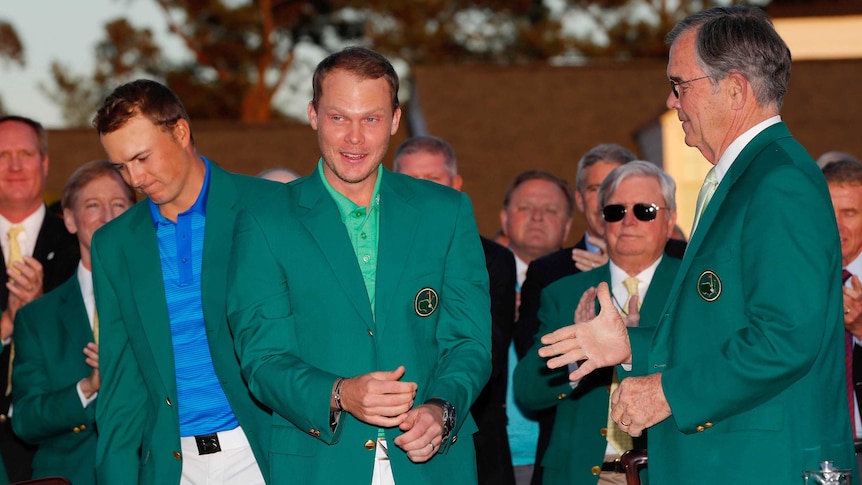 Danny Willett dons the Masters green jacket as Jordan Spieth looks on