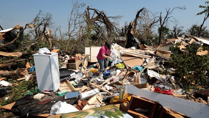 Kasey Clark sorts through debris after a tornado struck near Shawnee, Oklahoma on May 20, 2013.
