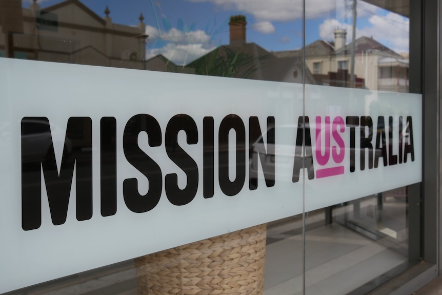 A Mission Australia sign on a window.