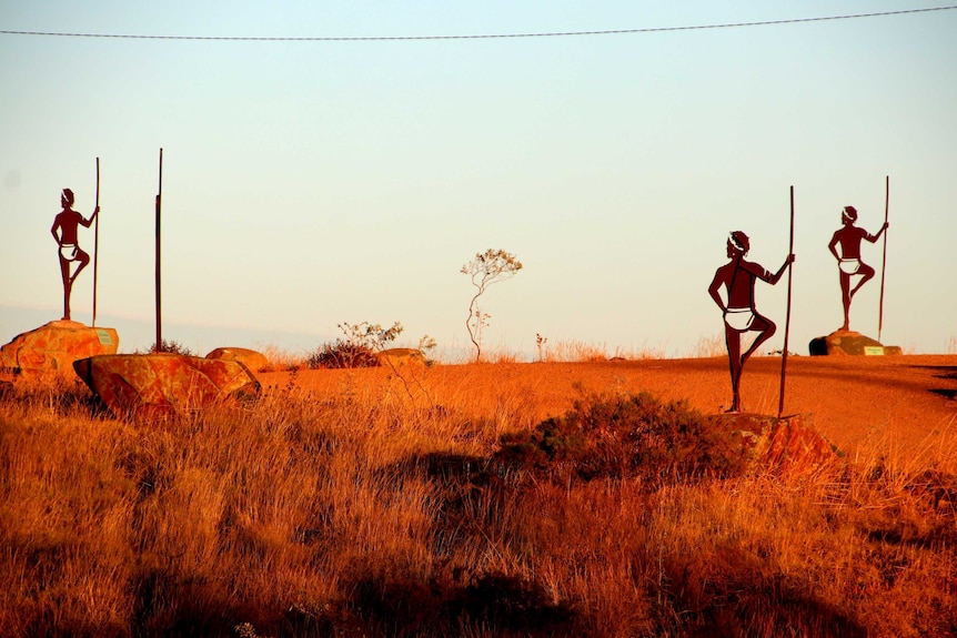 Three of six warrior statuess on top of Mt Welcome, photographed in the early morning light.