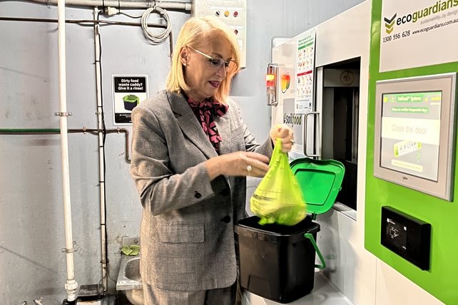 Lord Mayor Sally Capp putting food waste in FOGO bin.