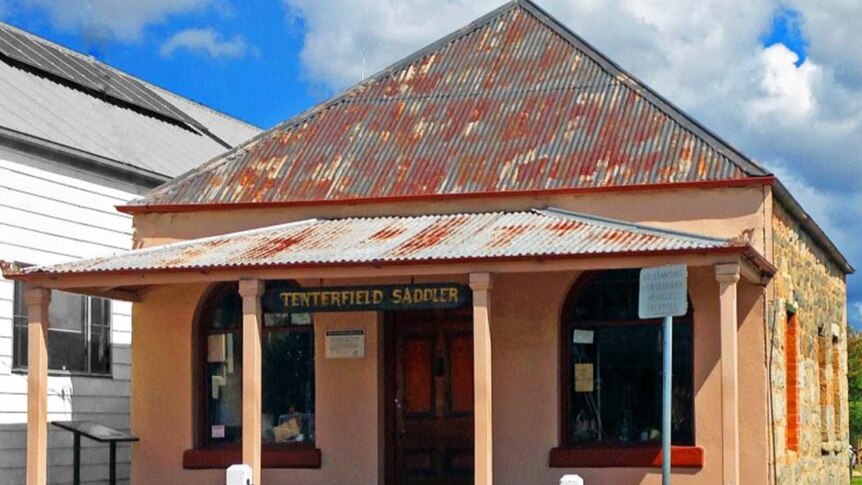 An old building with the sign Tenterfield Saddler hanging from the balcony ceiling