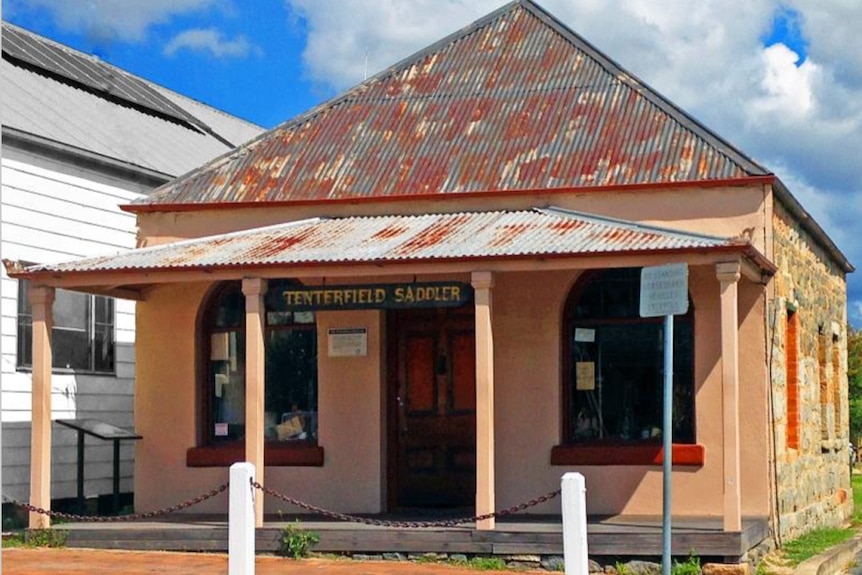 An old building with the sign Tenterfield Saddler hanging from the balcony ceiling