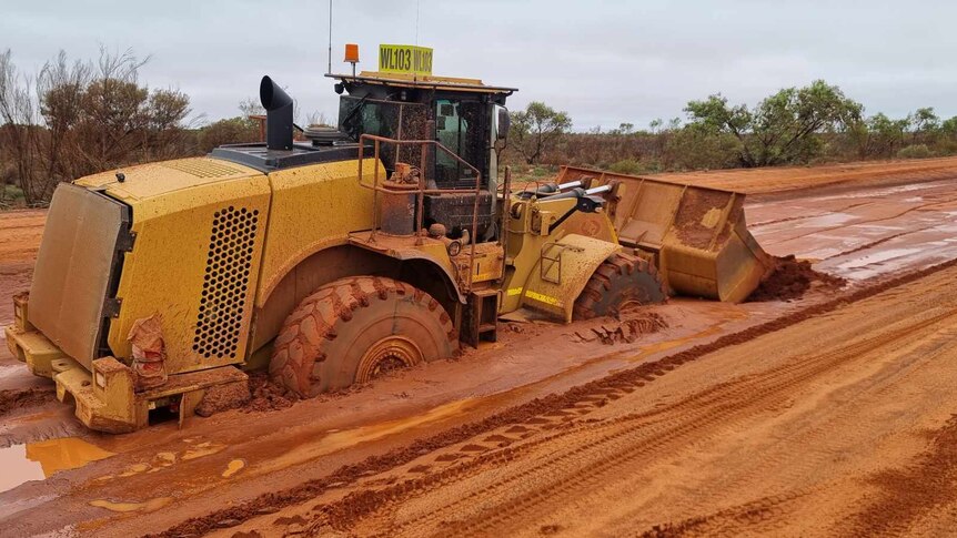 A grader bogged on the dirt road