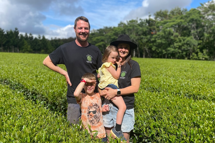 Image of a family standing in front of hedges.