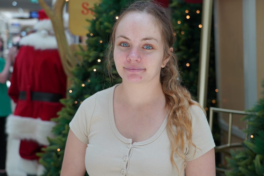 Kelsey smiles in a shopping centre.