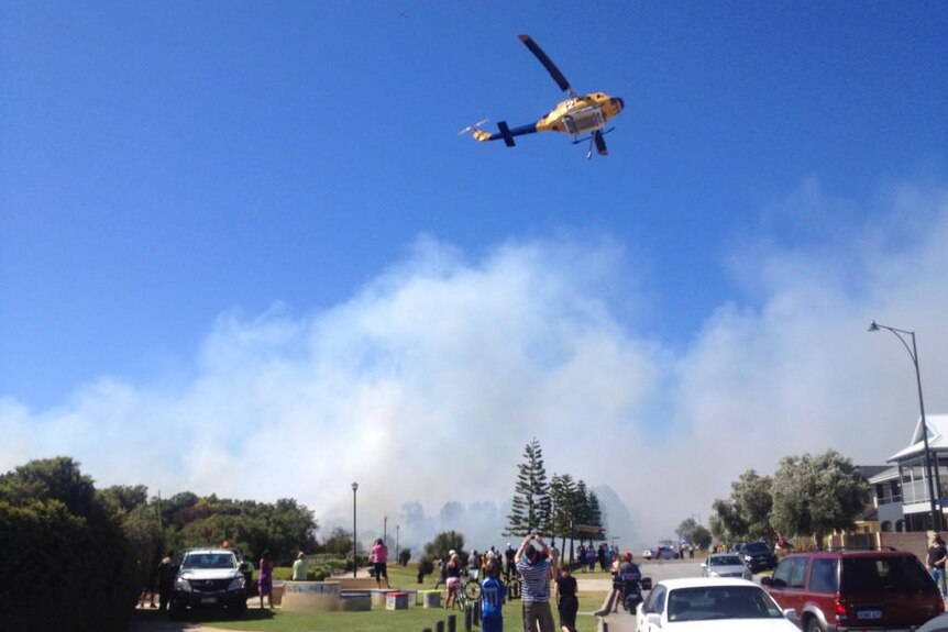 A helitac flies over Rockingham where a fire came close to homes.