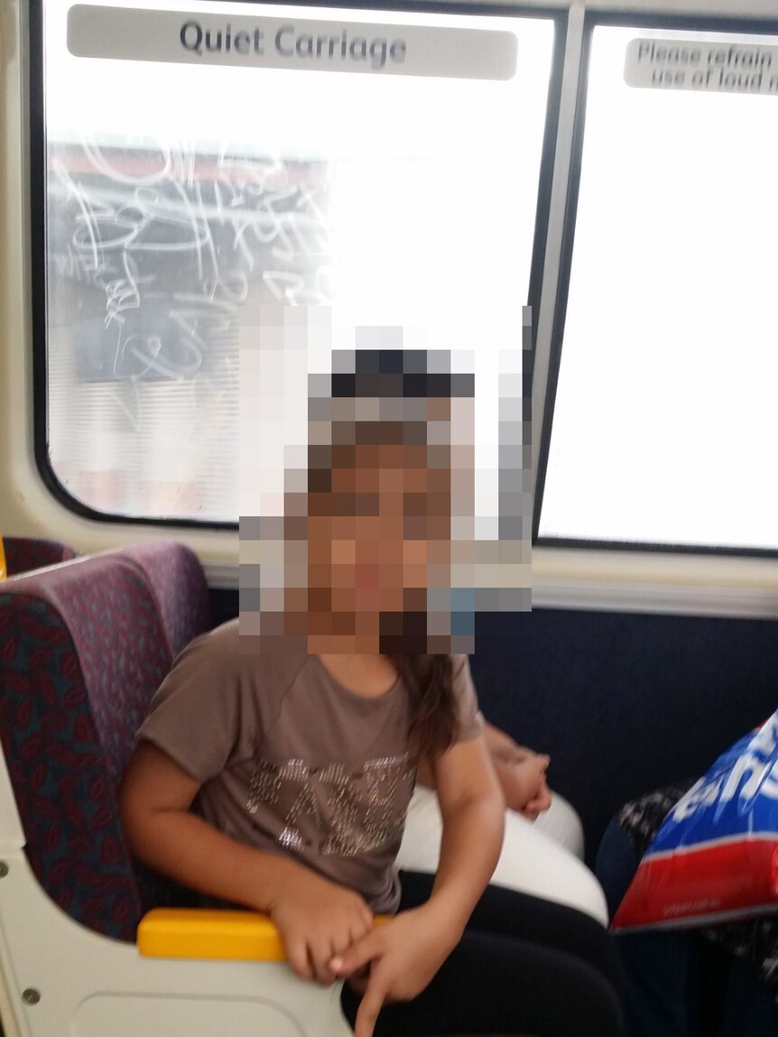 Children sitting on a train with their faces blurred.