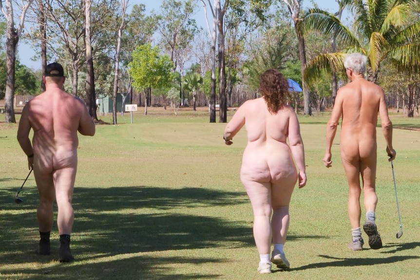 Three nude people walk across a golf green, with their backs to camera