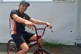 Teenage boy sits on a broken BMX bike