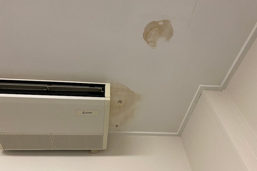 A room of a room in a building with an air-condition and water damage patches