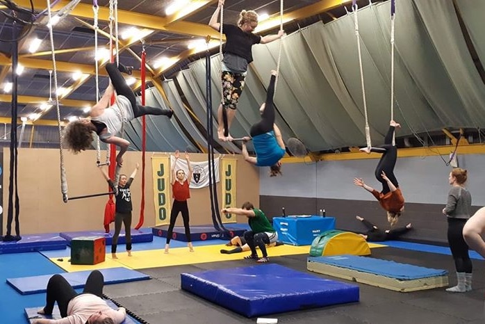 Kids hang from ropes at the circus studio.