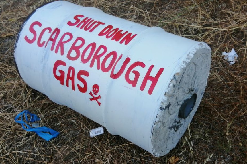 A concrete drum with spray paint on it.