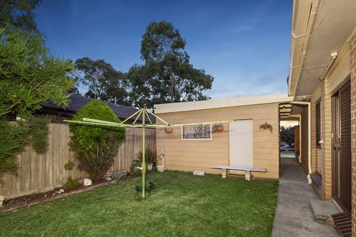 A backyard with a workshop and a clothesline.