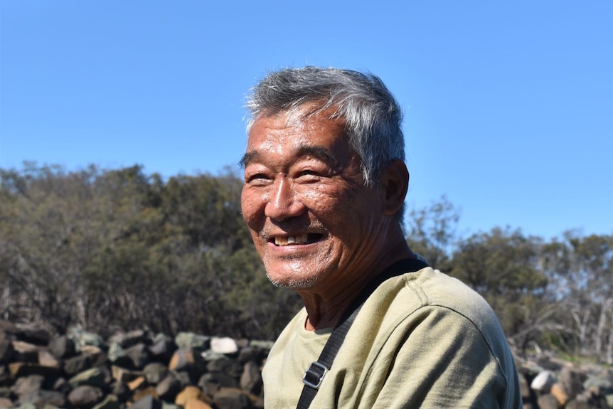 A Chinese man fishing at the coast