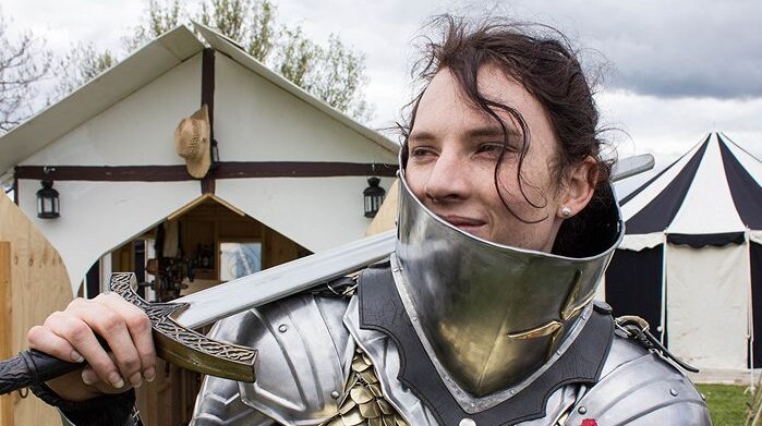 Women wearing armour and holding a sword on her shoulder at a medieval and fantasy festival in Gippsland
