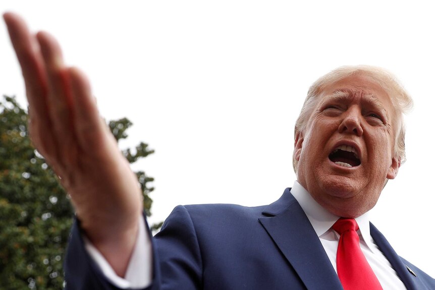 Donald Trump waving his hand and speaking.