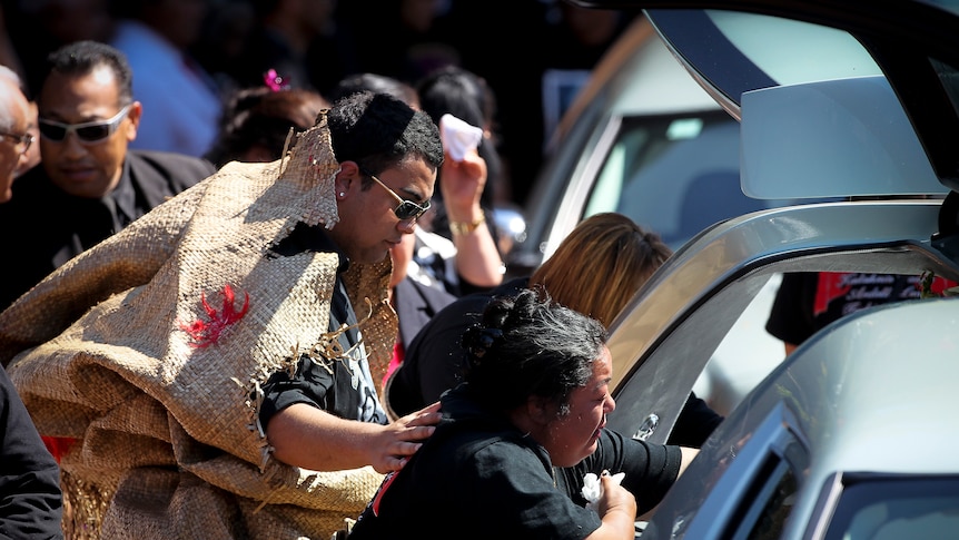 Taufa family members cry as they fairwell their relatives at a memorial service