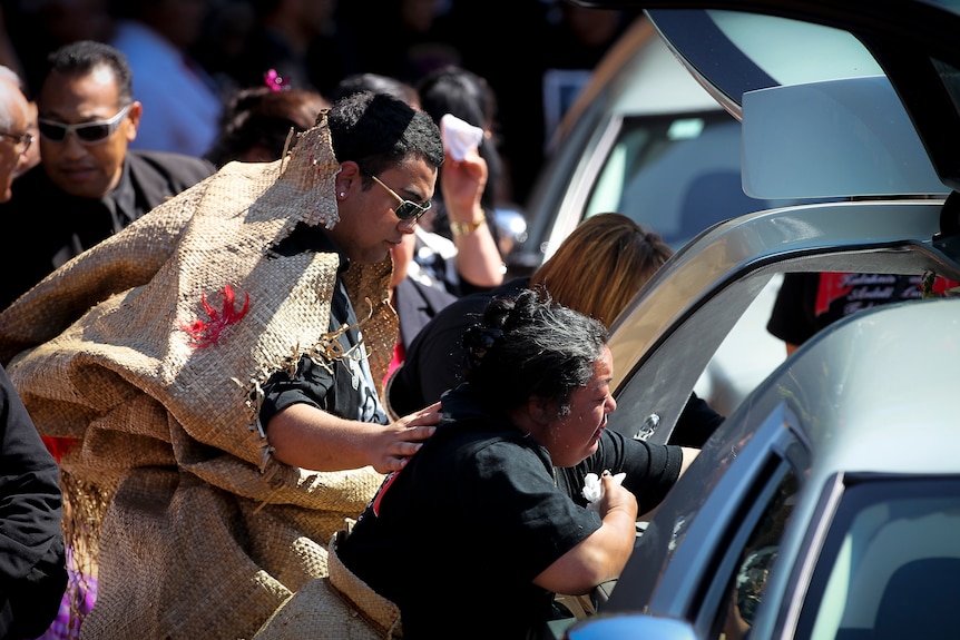 Taufa family members cry as they fairwell their relatives at a memorial service
