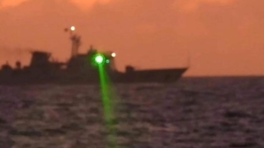 A Chinese Coast Guard vessel shines a "military grade laser light" at a Philippine Coast Guard boat.