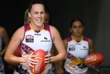 A smiling Emma Zielke leads the Brisbane Lions AFLW team onto Adelaide Oval
