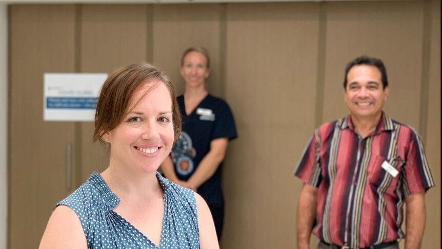 Dr Pippa May smiles, with staff in the background