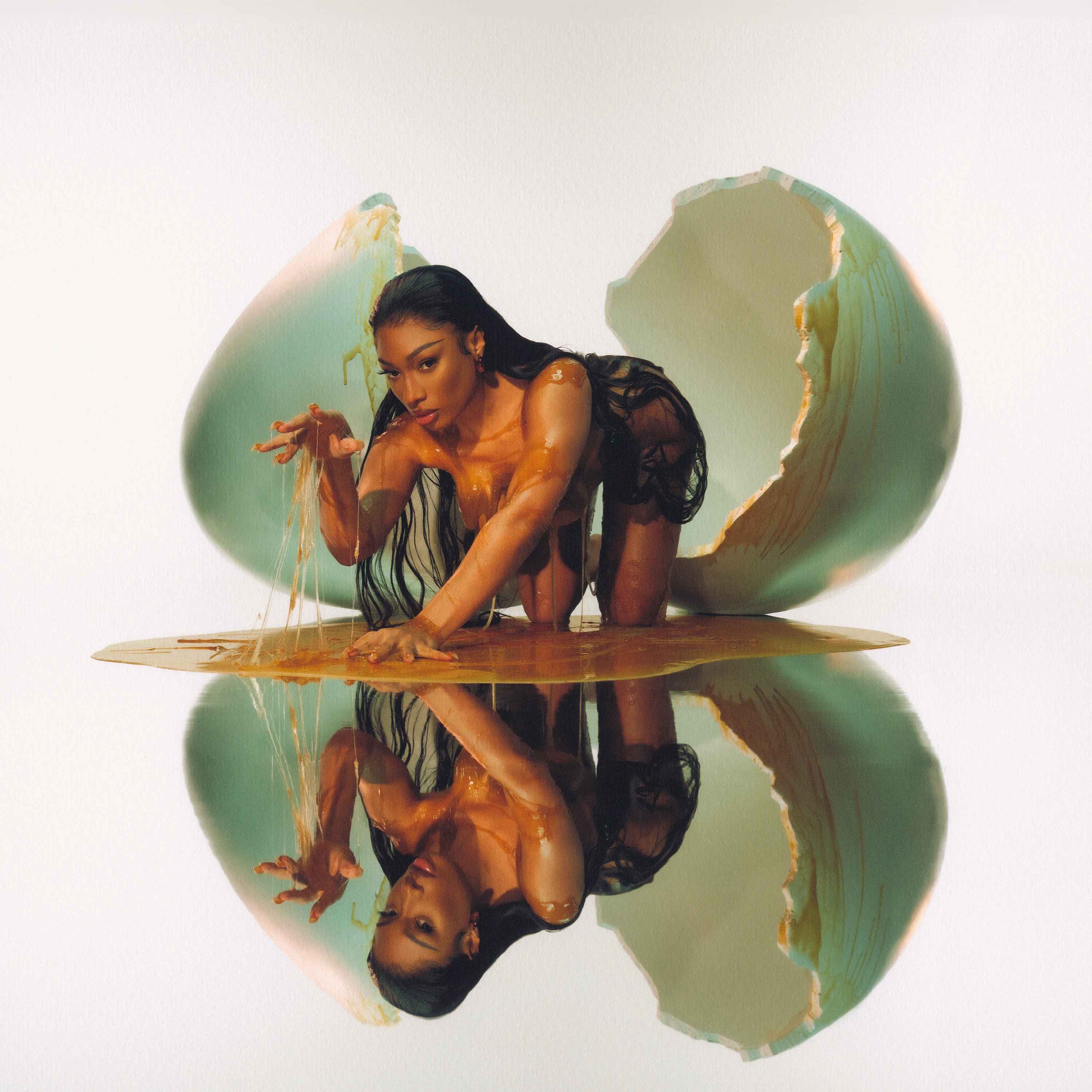 A naked Megan Thee Stallion emerges from a human-sized egg dripping yolk on a mirrored floor.