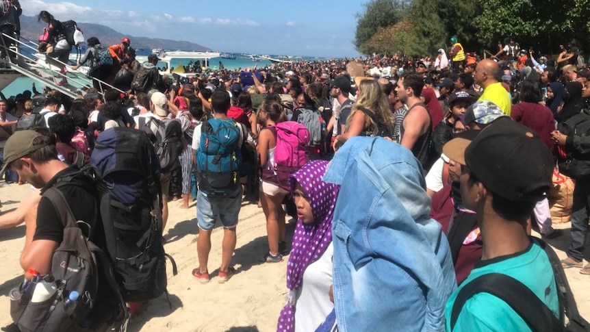 Tourists getting loaded onto boats in evacuation at Gili Island after a magnitude-6.9 earthquake.
