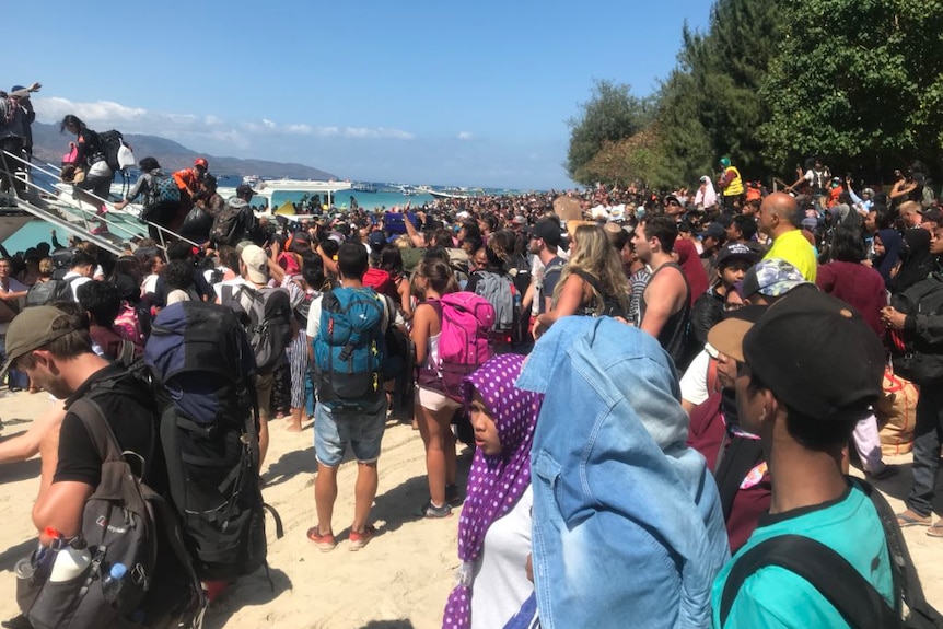 Tourists getting loaded onto boats in evacuation at Gili Island after a magnitude-6.9 earthquake.