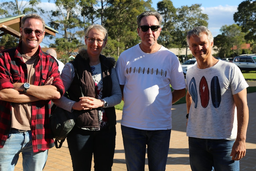 Four people stand and smile for the camera