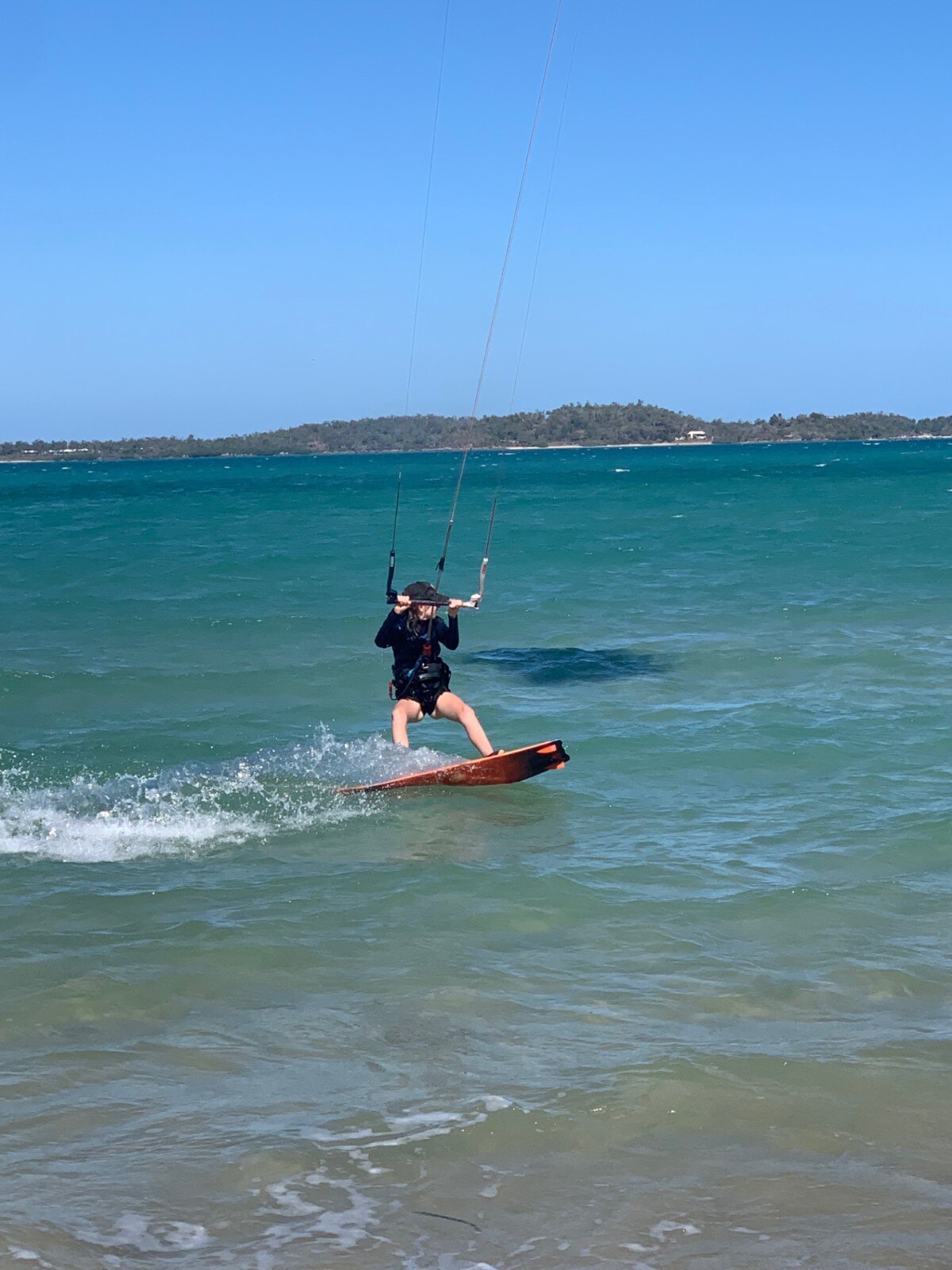 De 13-jarige Indi Young van Gove rijdt op een kiteboard op de oceaan.