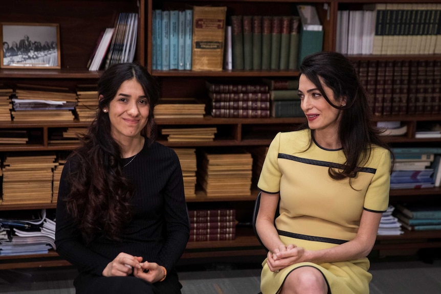 A Yazidi survivor sitting next to Amal Clooney during an interview.