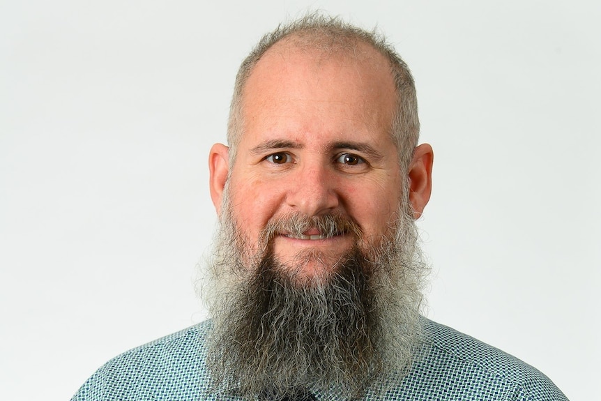 Headshot of Michael Grinceri, man with shirt and tie and grey beard