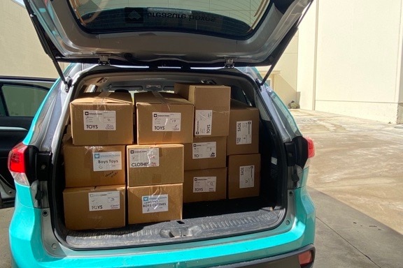 A hatchback car with its back door open showing a boot full of boxes