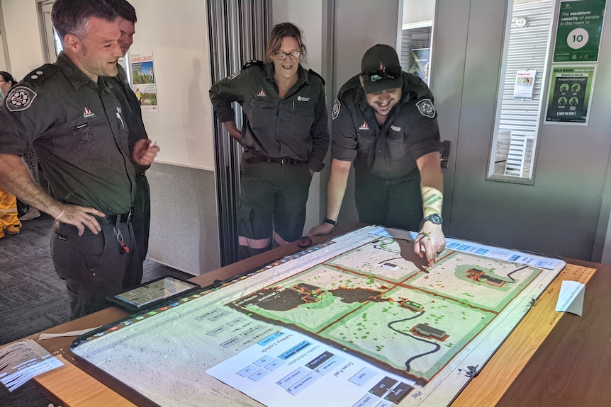 Three fire officers from NT fire services pointing to game