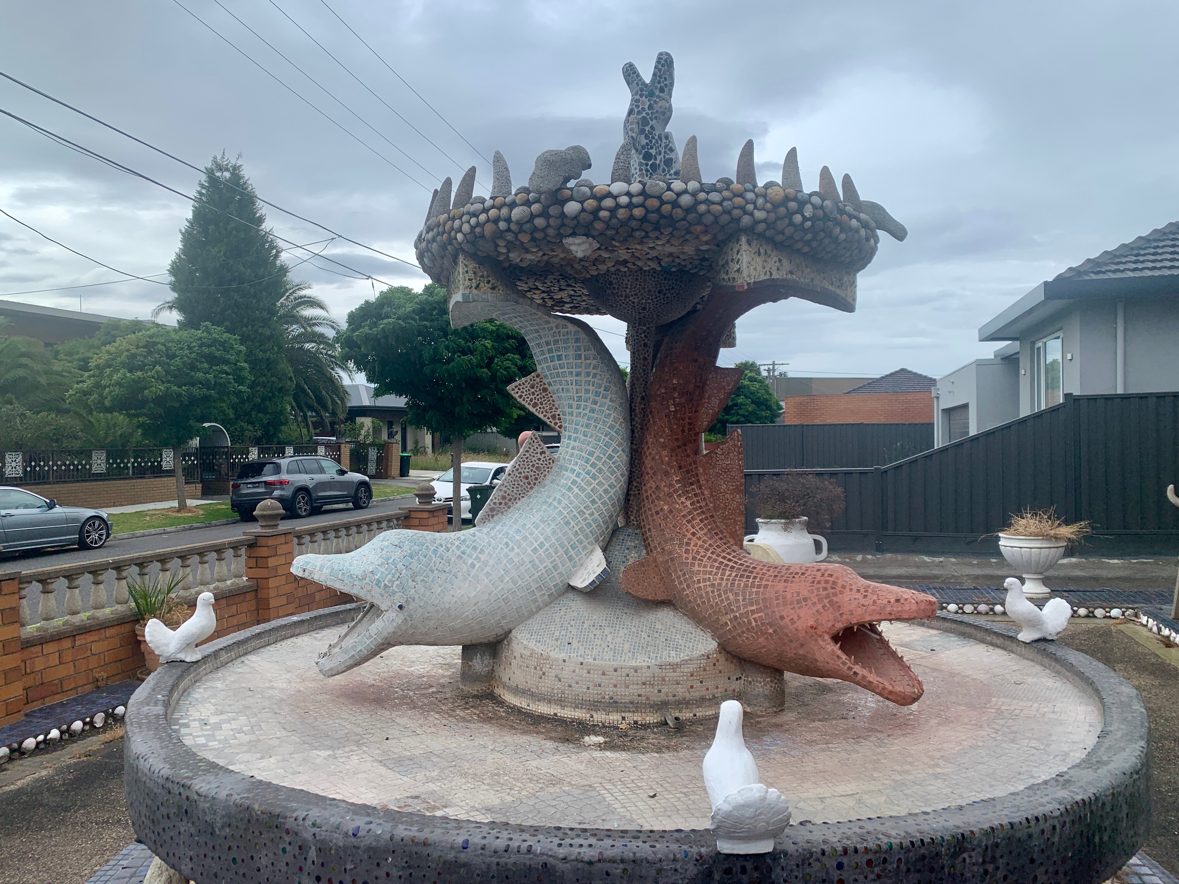Image of a stone fountain with large mosaic dolphins.