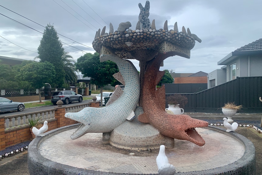 Image of a stone fountain with large mosaic dolphins.
