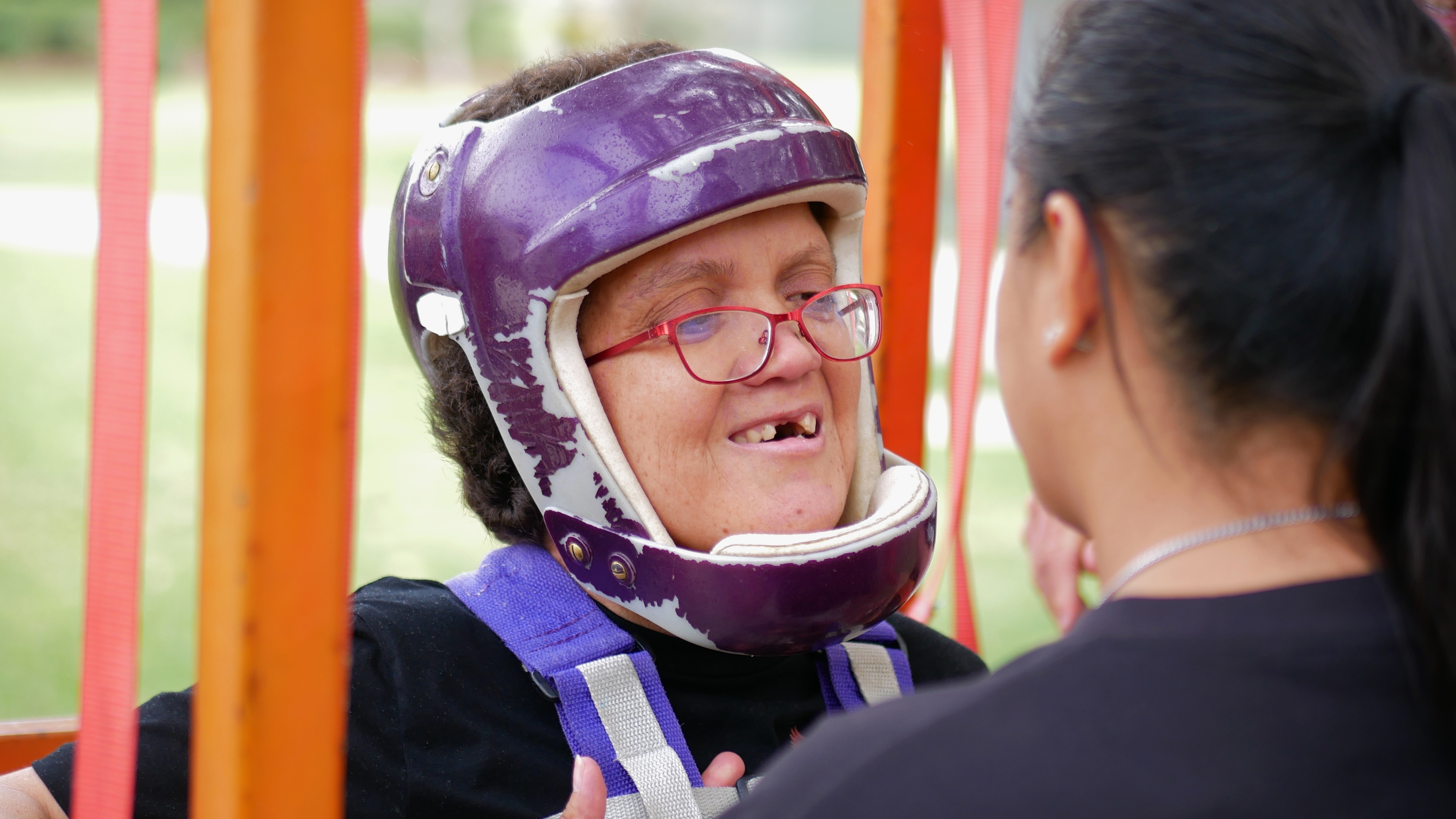 Mulher em um arnês usando capacete e óculos