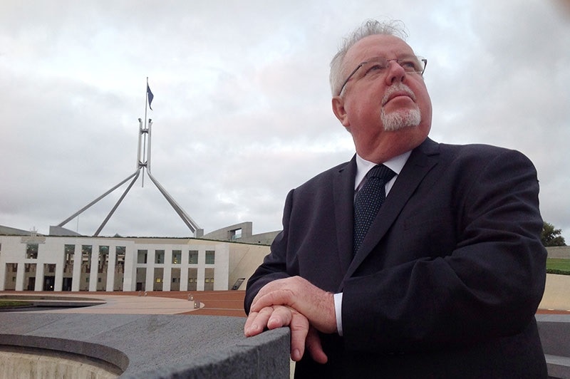 LNP Senator Barry O'Sullivan gazes skywards outside Parliament House in Canberra.