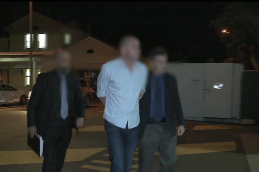 Markis Scott Turner, face blurred, being escorted by two police officers in 2011