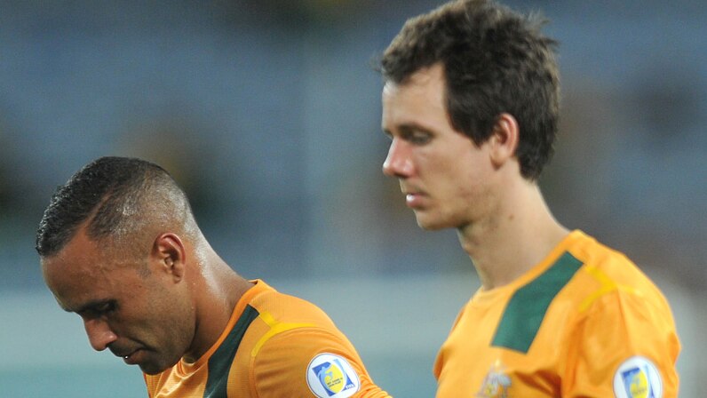 Australia's Archie Thompson and Robbie Kruse leave the pitch after a 2-2 draw with Oman in their World Cup qualifier in Sydney.