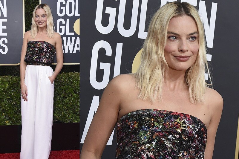 Margot Robbie wearing a bedazzled top with a silky white skirt.