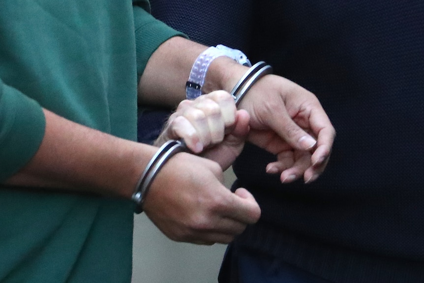 A man wearing handcuffs