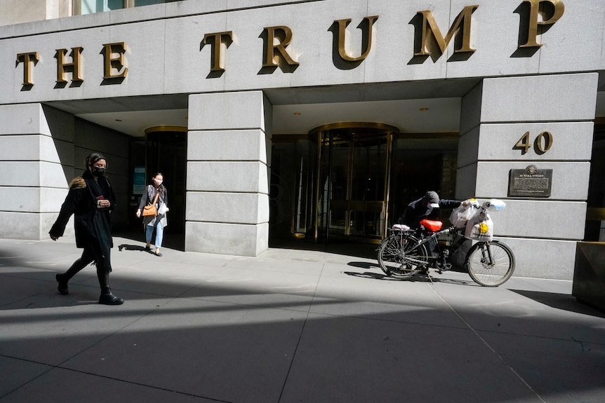 Pedestrians and a food delivery man are seen outside the Trump building.