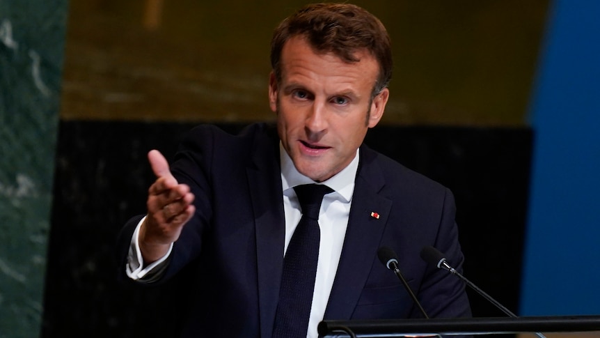Emmanuel Macron gestures towards the audience as he speaks from the UN podium.