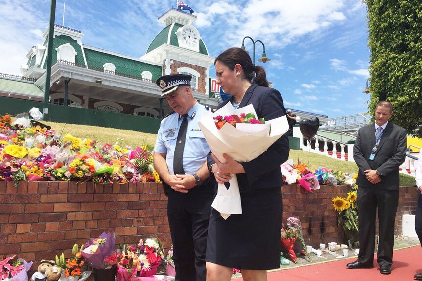 Queensland Premier Annastacia Palaszczuk lays flowers outside Dreamworld